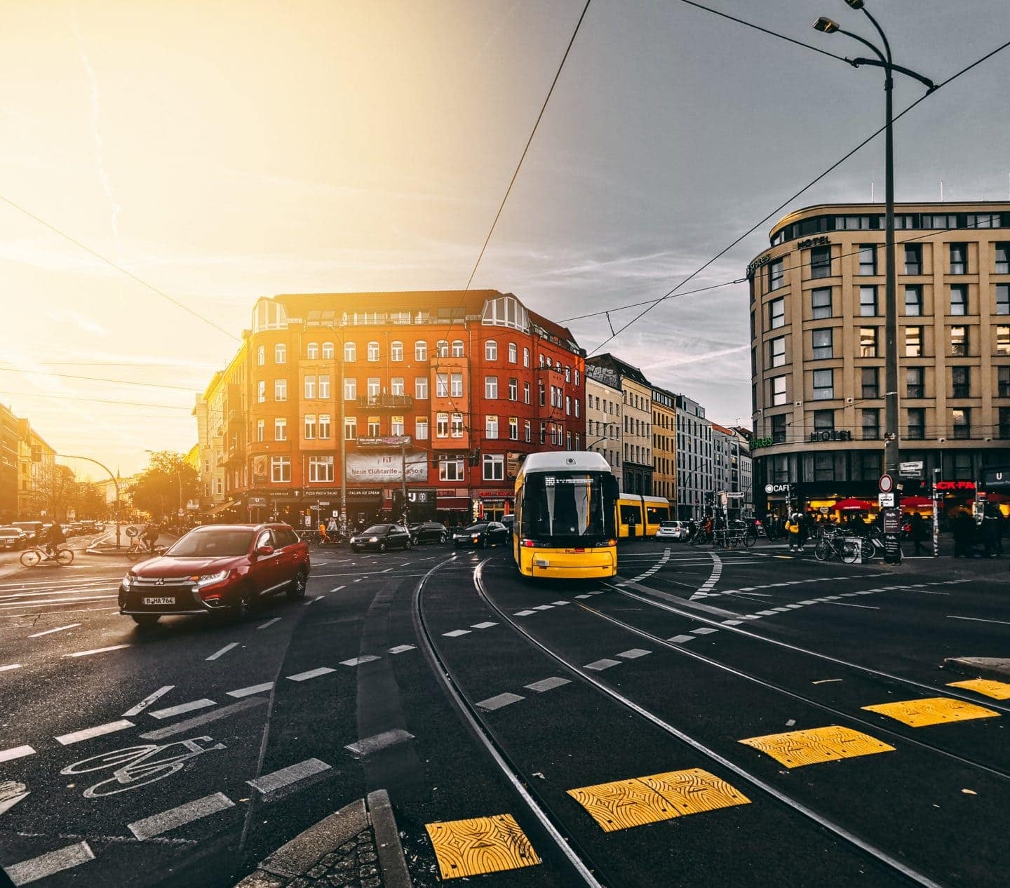 Straßenbahn fährt im Sonnenuntergang über Kreuzung in Berlin